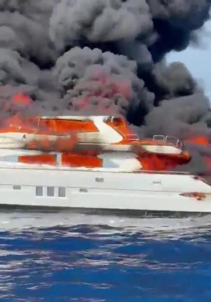 Burning yacht sinking in the ocean.