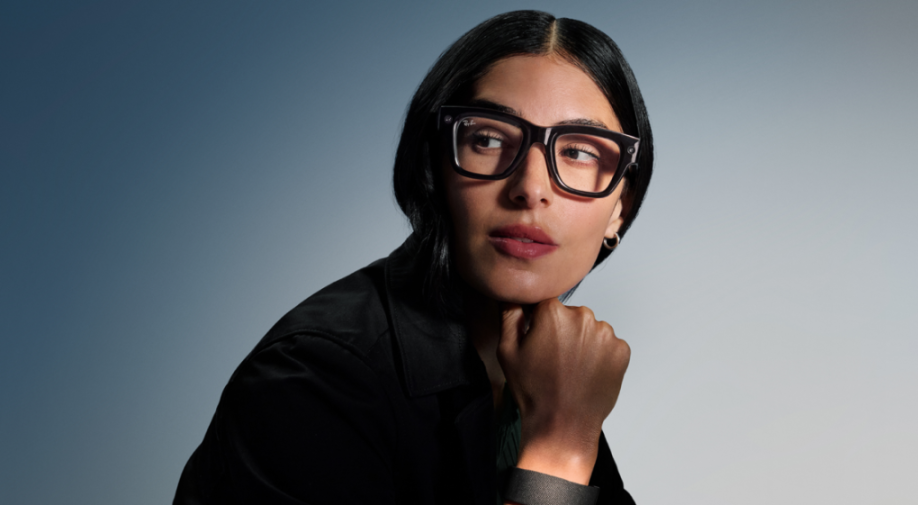 A woman wearing black eyeglasses and a black shirt looks to her right.