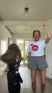 A woman and a child dancing in a house.