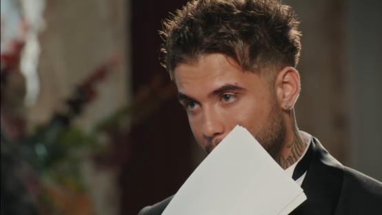 Man in suit looking down at papers.