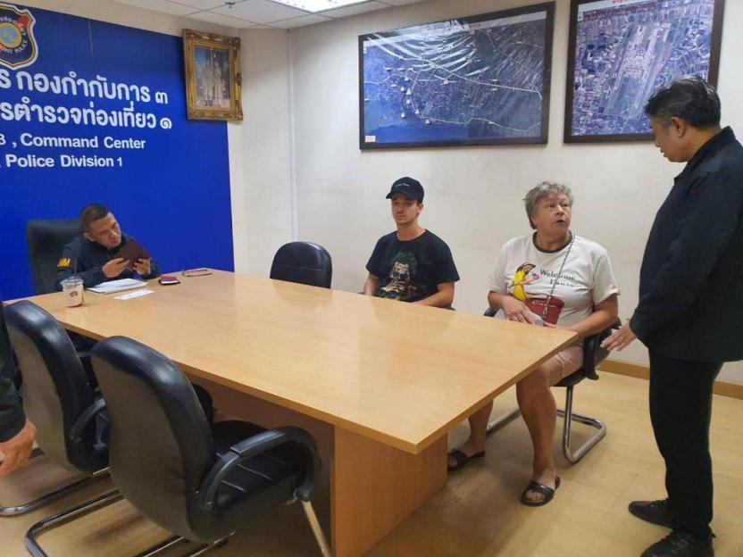 People in a room with a police officer and maps on the wall.