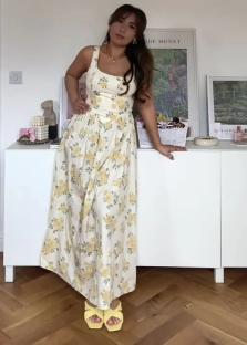 Woman in yellow floral maxi dress and yellow sandals.