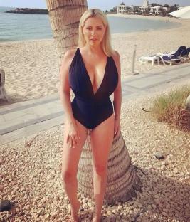 Woman in black swimsuit on beach.