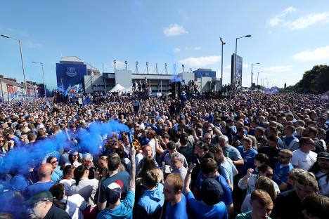 Everton fans with blue flares outside Goodison Park.