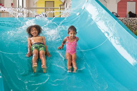 Two children going down a water slide.