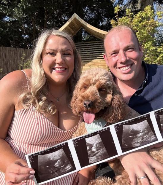 Couple announcing pregnancy with ultrasound images and dog.