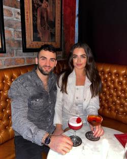 Couple sitting at a bar with cocktails.