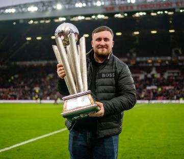 Luke Littler, English darts player, holding a trophy at Old Trafford.