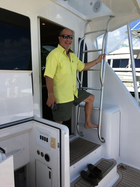 Martin Suarez standing on a yacht ladder while holding a phone.