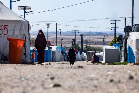 People walking in a refugee camp.