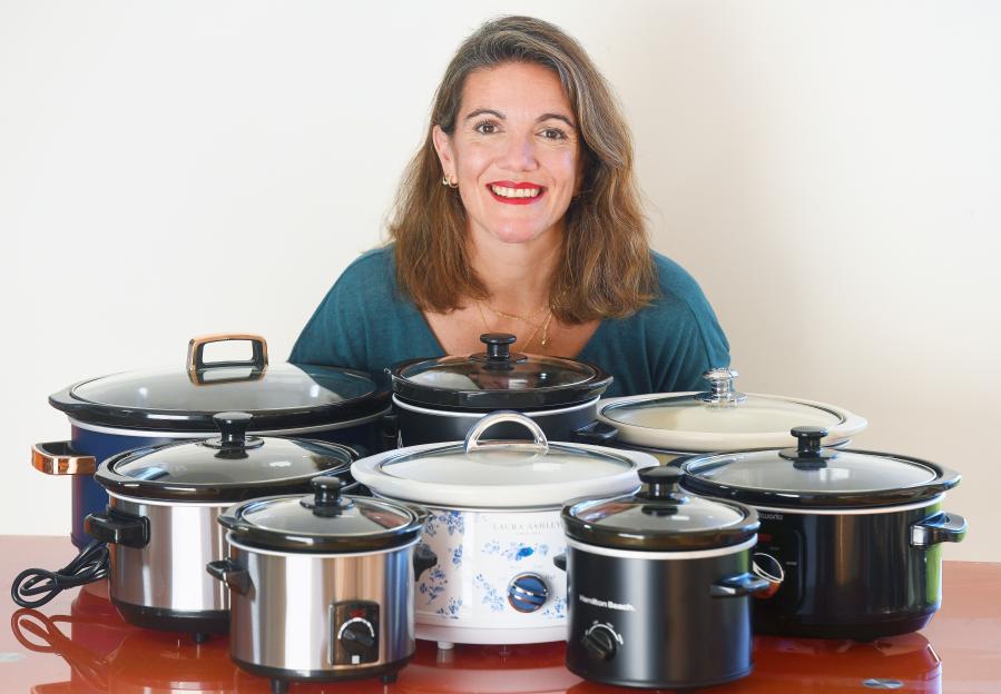 Woman surrounded by various slow cookers.