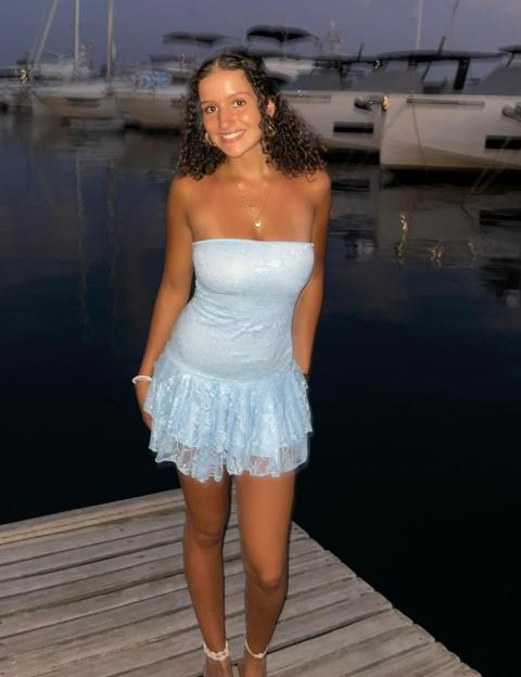 Yas Labidi in a light blue dress at a marina.