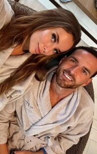 Couple in bathrobes cuddling.
