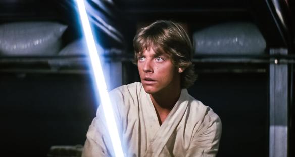 Luke Skywalker with a lightsaber in Star Wars: A New Hope.