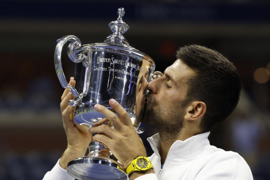 Novak Djokovic kissing the US Open trophy.