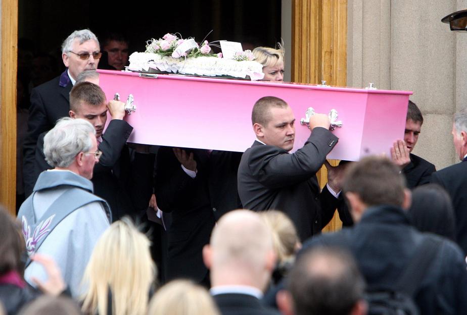 Pallbearers carry a pink coffin from a church.
