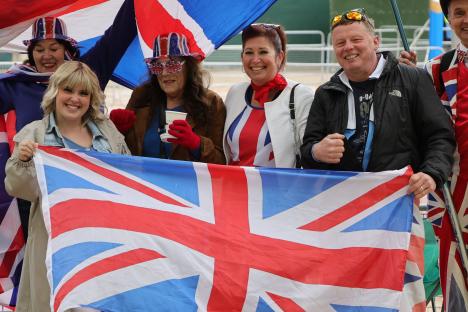 Royal fans holding a Union Jack flag at a VE Day celebration in London.