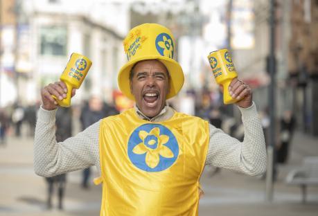 Chris Kamara, a football broadcaster and Marie Curie ambassador, holding donation buckets.