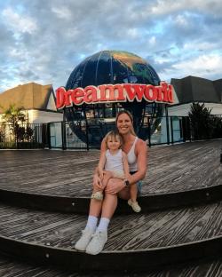 Woman and child sitting in front of Dreamworld globe.