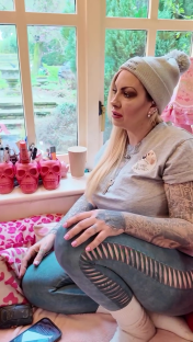 Jodie Marsh, wearing a grey beanie and grey t-shirt, sits and talks.