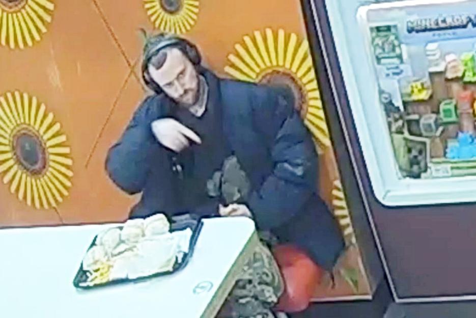 Moment McDonald’s customer points GUN at teens while revealing stab-proof vest – before waving weapon at cop
