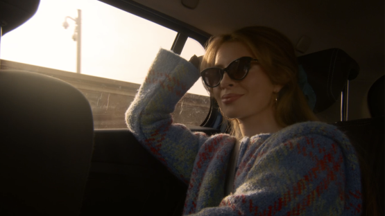 Woman wearing sunglasses in a car.