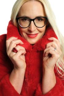 Woman in a red fur coat and glasses.
