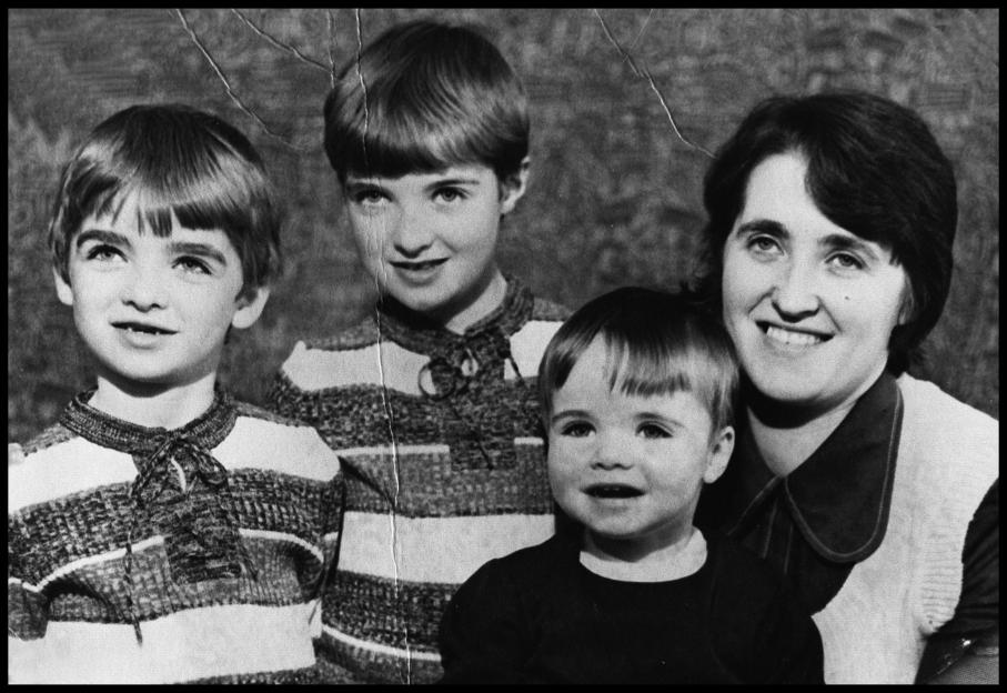 Black and white photo of Noel, Paul, Liam Gallagher, and their mother Peggy.