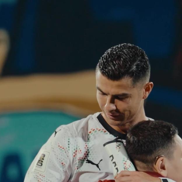 Cristiano Ronaldo consoles a crying young mascot.