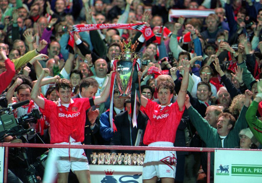 Steve Bruce and Bryan Robson of Manchester United holding the FA Premier League trophy.