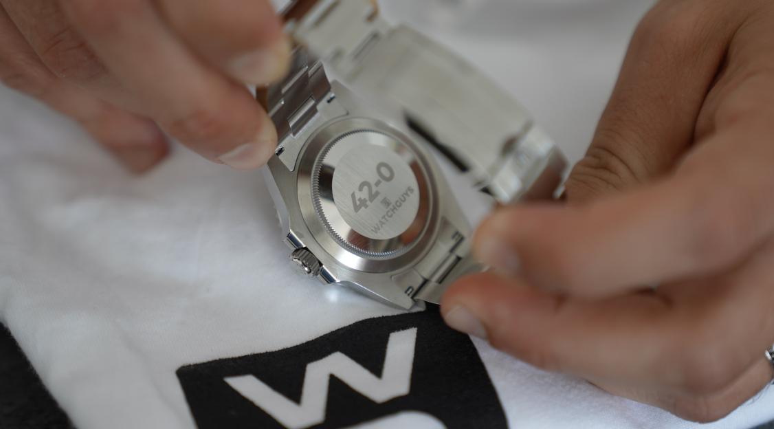 Close-up of hands adjusting a watch bracelet.