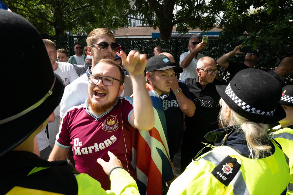 A man uses a megaphone to address police officers during a protest.