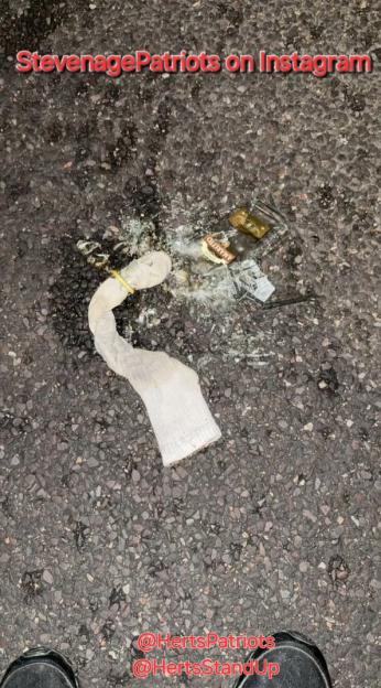 Broken bottle and sock on the ground.