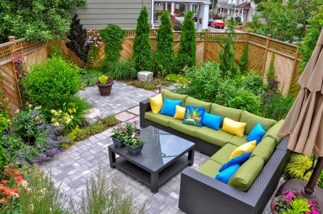 Small urban backyard with patio furniture and lush landscaping.