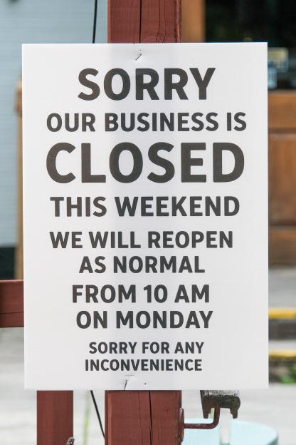Sign stating business closure this weekend, reopening Monday at 10 AM.