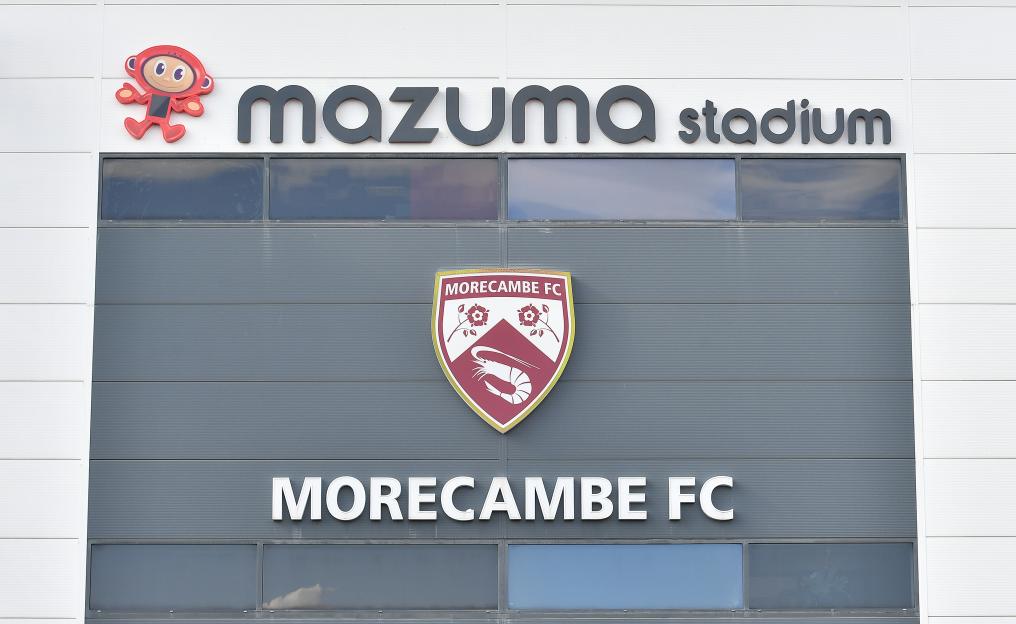 Mazuma Stadium exterior with Morecambe FC logo.