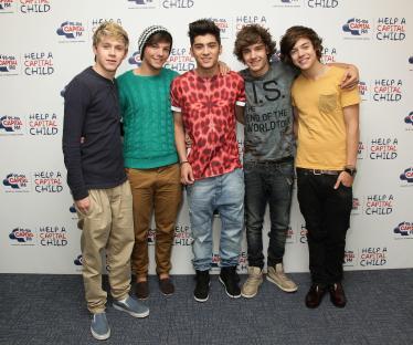 Four One Direction members: Louis Tomlinson, Niall Horan, Liam Payne, and Harry Styles at a secret X Factor gig.