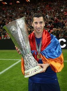 Henrikh Mkhitaryan of Manchester United holding the Europa League trophy.