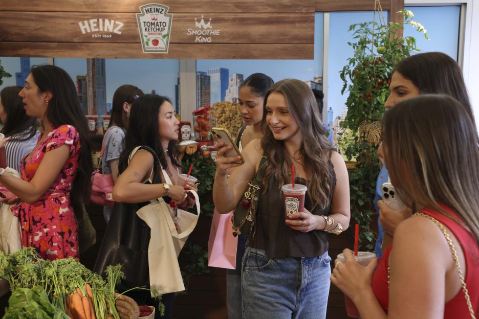Women at a Heinz and Smoothie King event holding tomato ketchup smoothies.