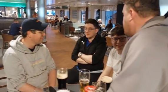 Four people sitting at a table in a bar, drinking.