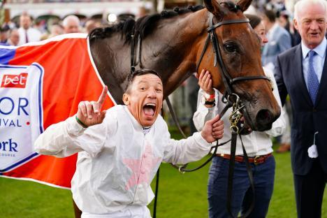 Frankie Dettori celebrating a horse race win.