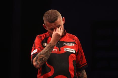 Nathan Aspinall of England reacts during a darts match.