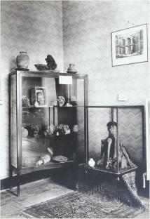 Black and white photo of South American mummies and artifacts in display cases.