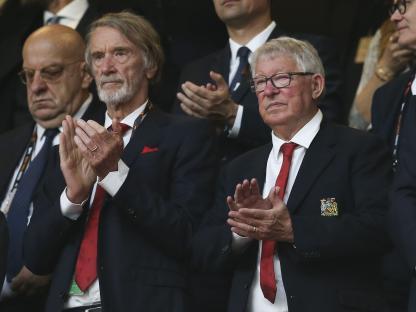 Sir Jim Ratcliffe and Sir Alex Ferguson applauding at a football match.