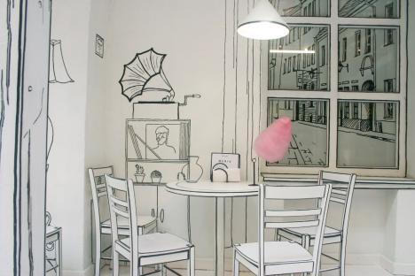 Illustration of a cafe interior with cartoon-style wall art and a table with chairs.