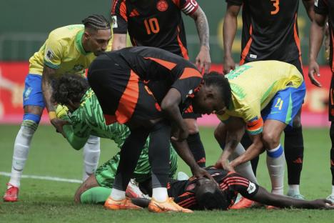 Colombia's Davinson Sanchez lays on the ground after colliding with Brazil's goalkeeper Alisson, during a FIFA World Cup 2026 qualifying soccer match at Mane Garrincha stadium in Brasilia, Brazil, Thursday, March 20, 2025. (AP Photo/Eraldo Peres)