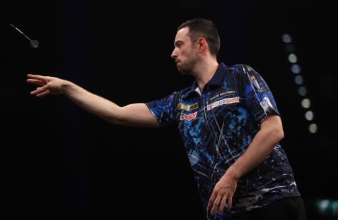 Luke Humphries throwing a dart during a match.