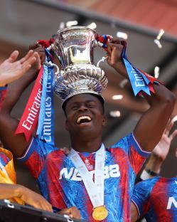 Marc Guehi of Crystal Palace holding the FA Cup trophy above his head.