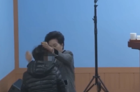 A woman grabbing another woman's hair.