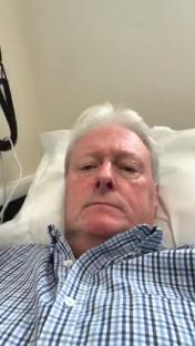 A man lying in a hospital bed.
